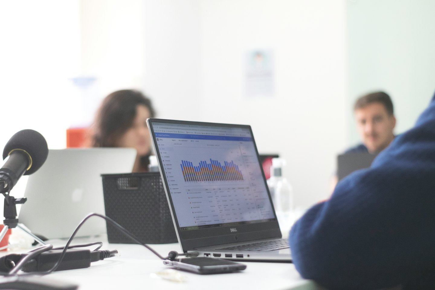 Biznesmen pracuje na laptopie z wykresami przy biurku.